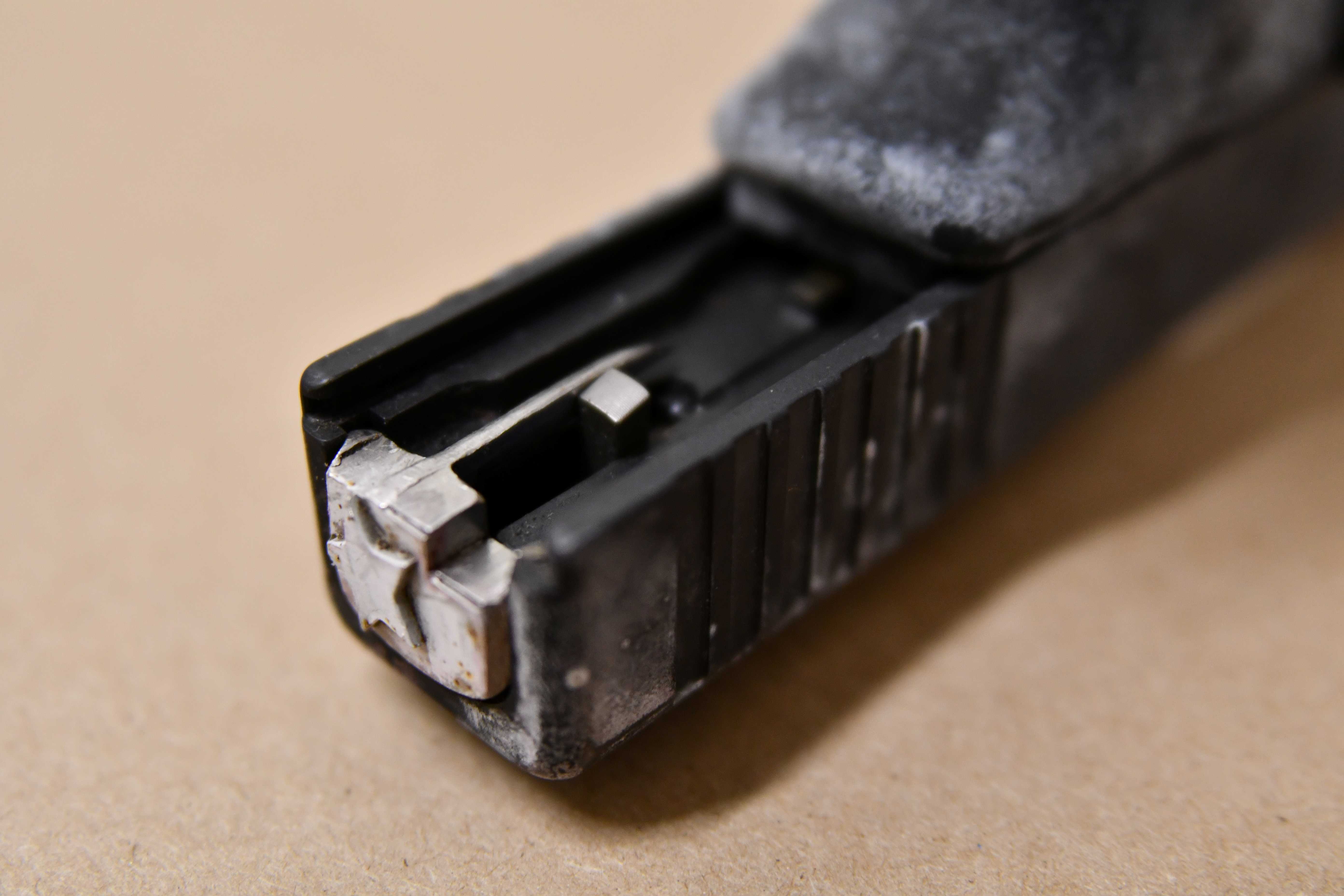 A close up of a machine gun conversion device on a firearm.