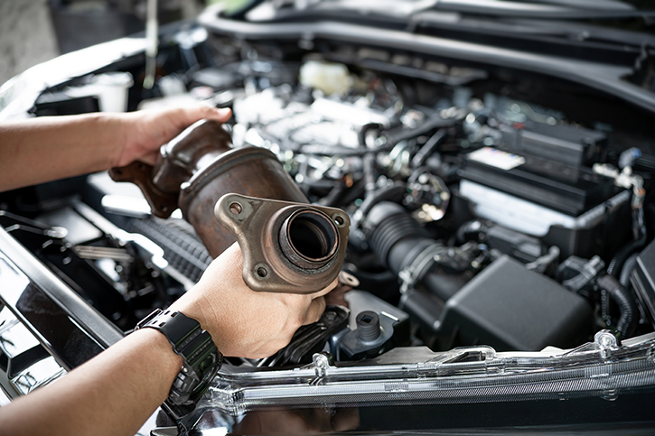 Image of a hands holding a catalytic converter