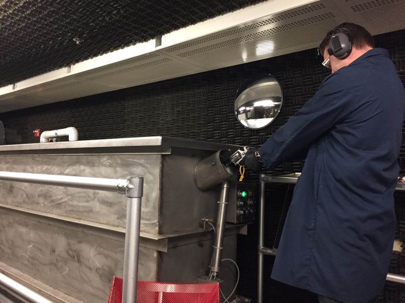 A firearms examiner shooting into a water trap