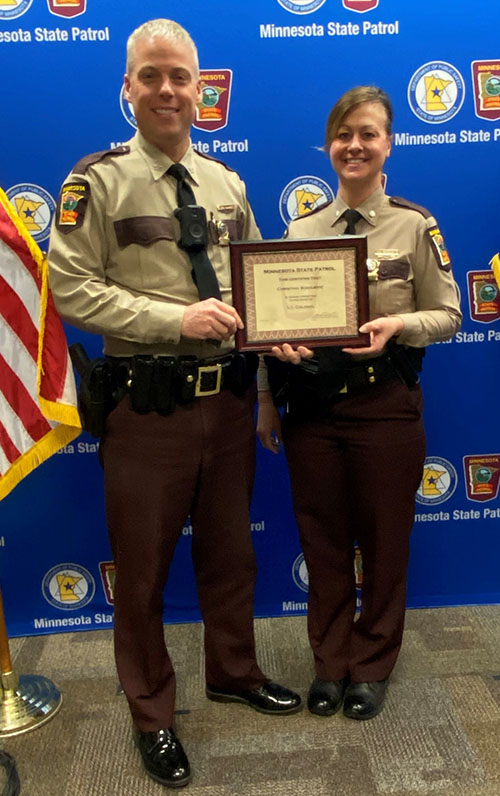 Lt. Col. Christina Bogojevic and Col. Matt Langer holding a certificate and posing for the camera during a promotion ceremony