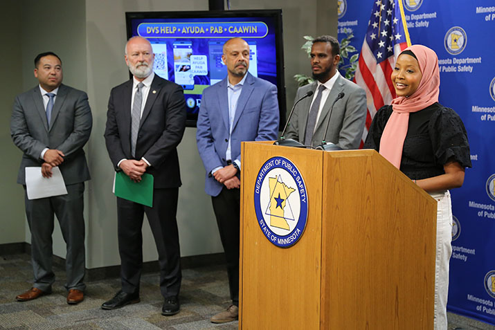 Somali community member Yasmin Aden speaking as four other news conference participants stand behind her.
