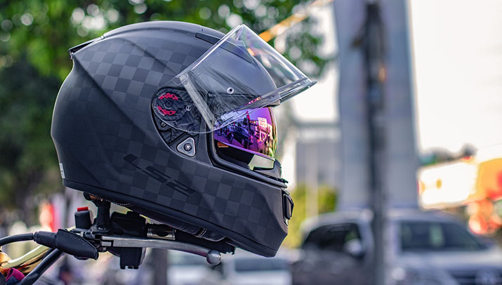 A helmet sitting on the handlebars of a motorcycle