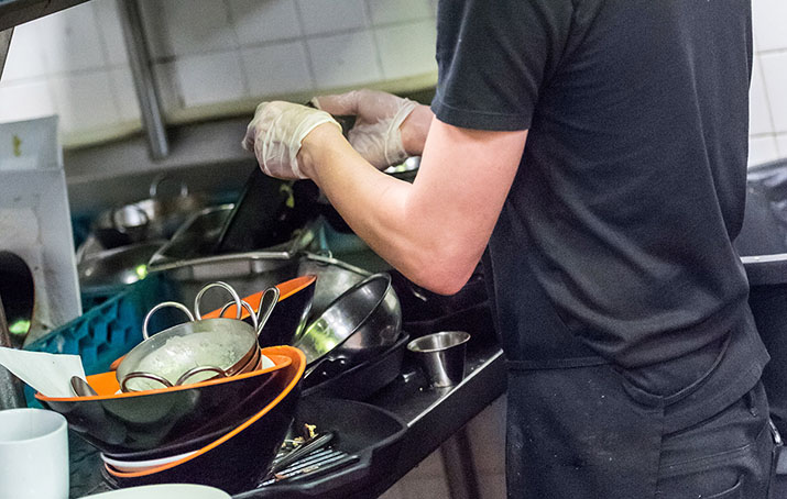 A person washes dishes in a restaurant