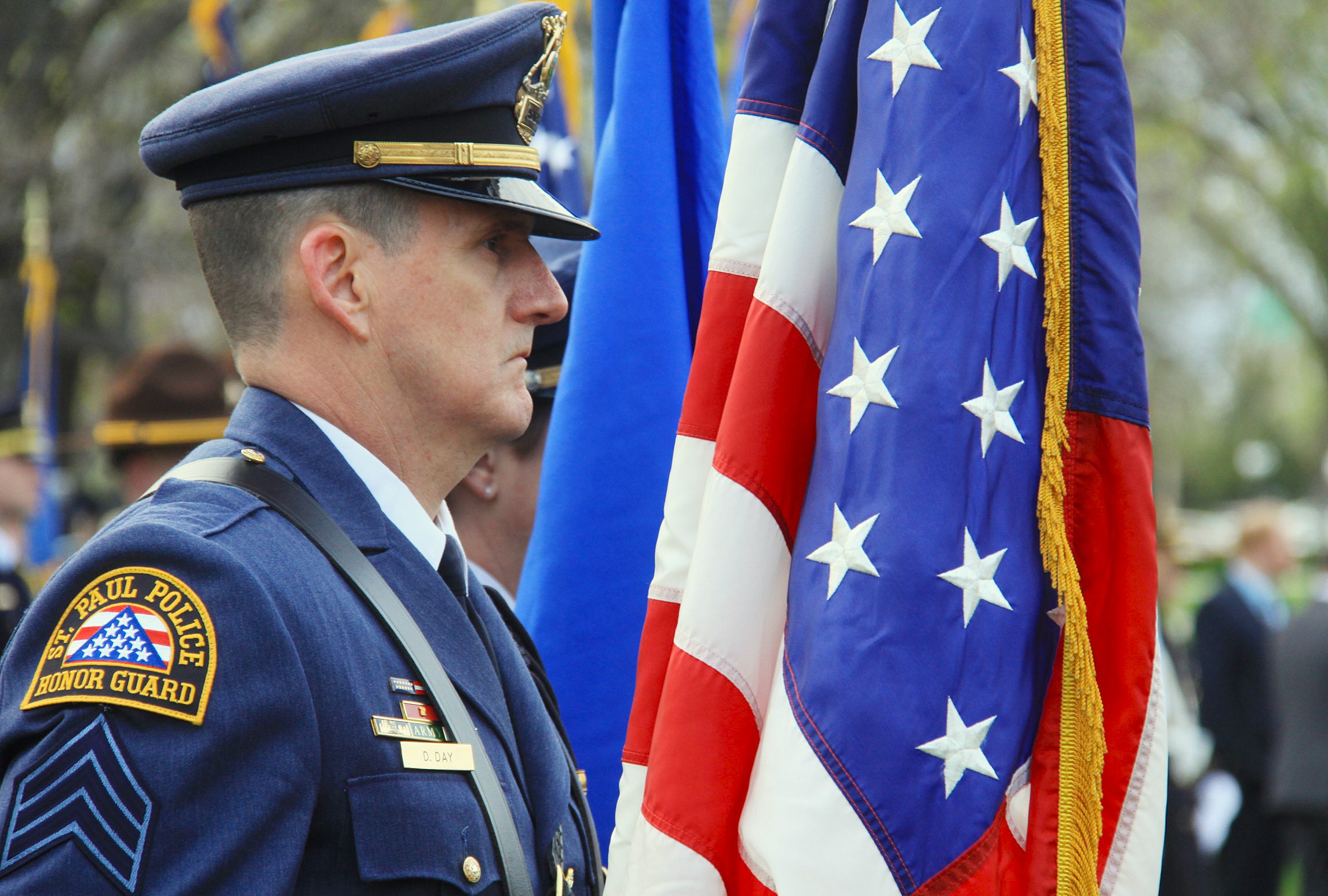 A St. Paul police honor guard member stands near an American flag. 