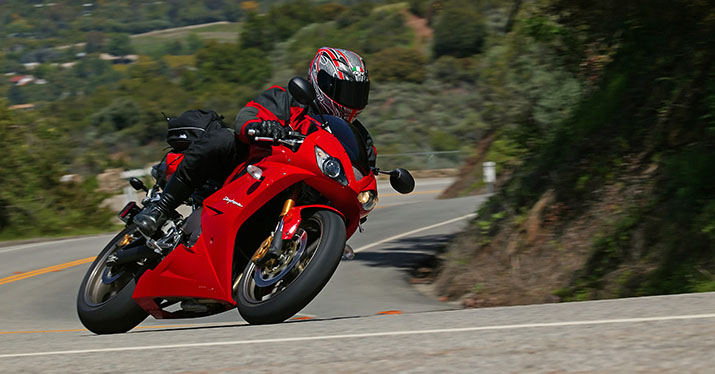 A motorcyclist wearing a helmet safely negotiates a curve.