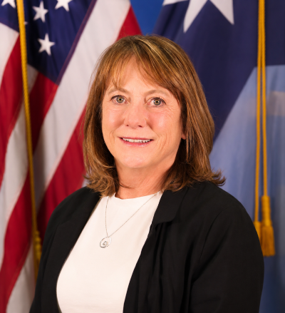 Connie Forster smiling in front of flags