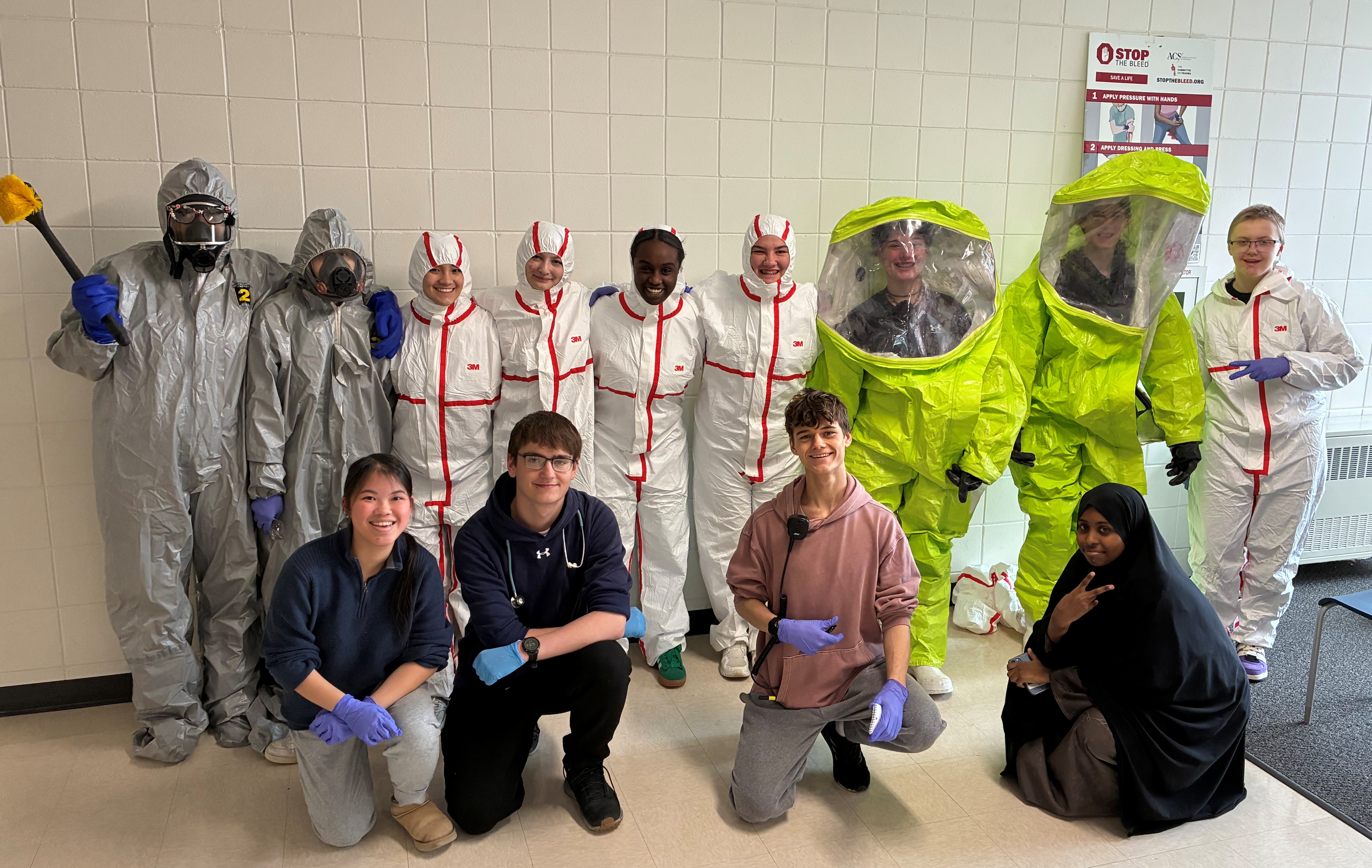 Group of high school students wearing practice hazmat gear.