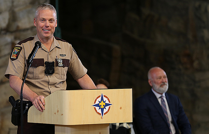 Col. Matt Langer stands at a lectern and gives a speech at his going-away ceremony.