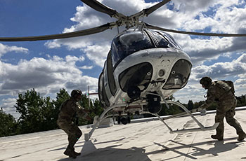 Special Response Team members getting onto a hovering helicopter