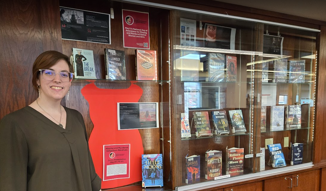 Librarian standing next to an MMIR book display