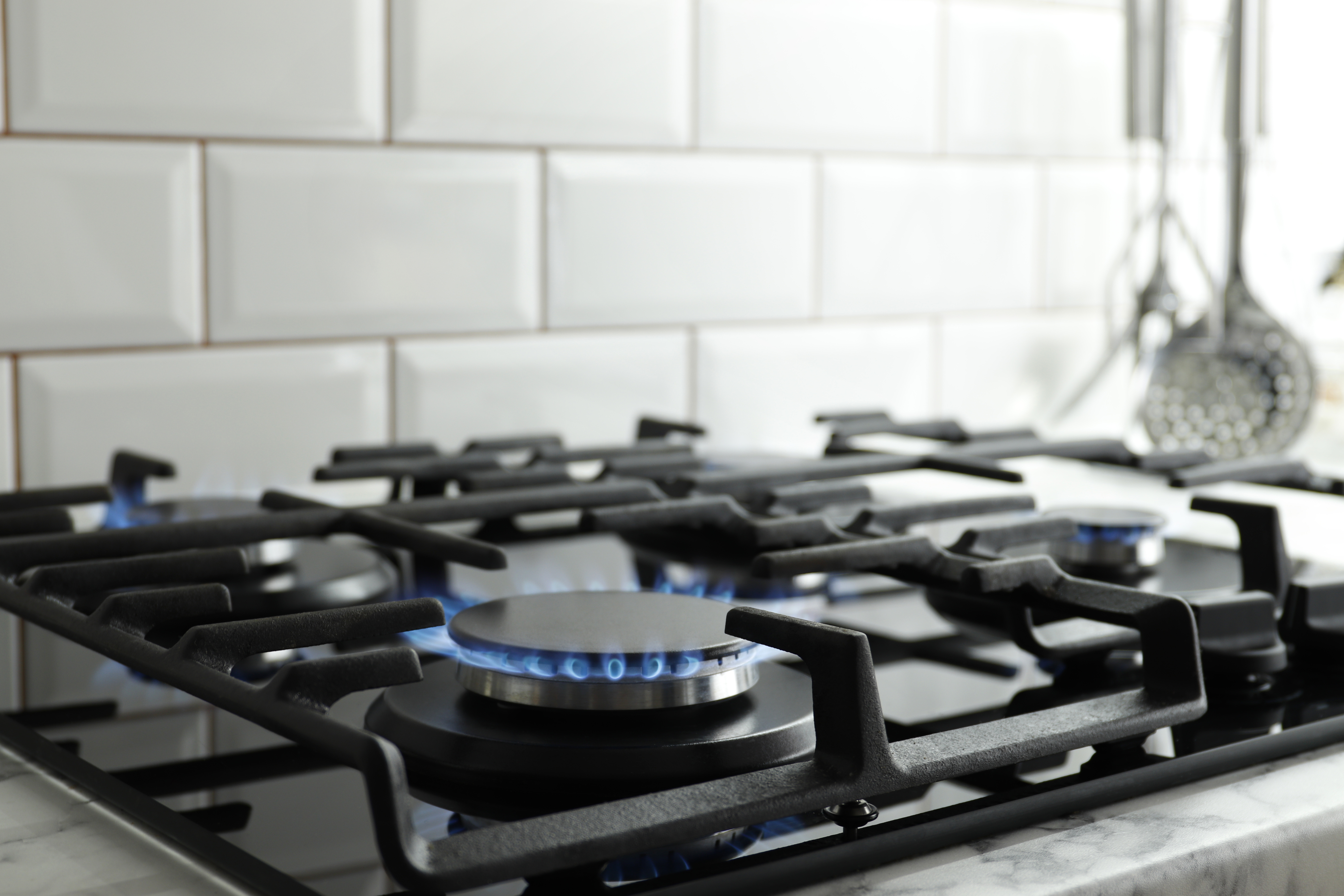 Close-up of a gas stovetop. One burner is on. 
