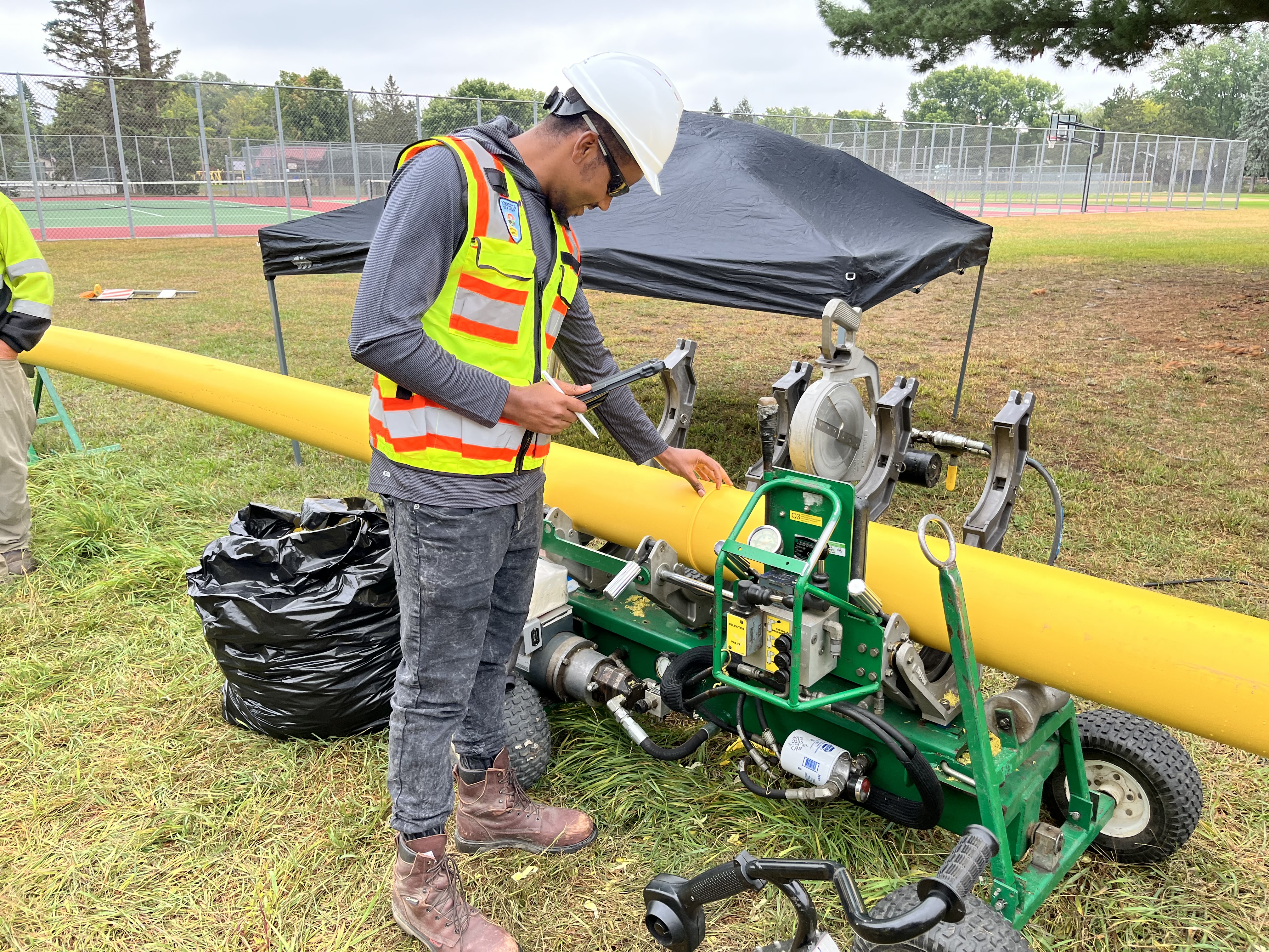 A pipeline inspector looking at a pipe seam in the field