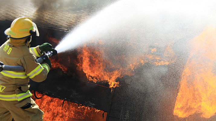 A firefighter spraying water on flames