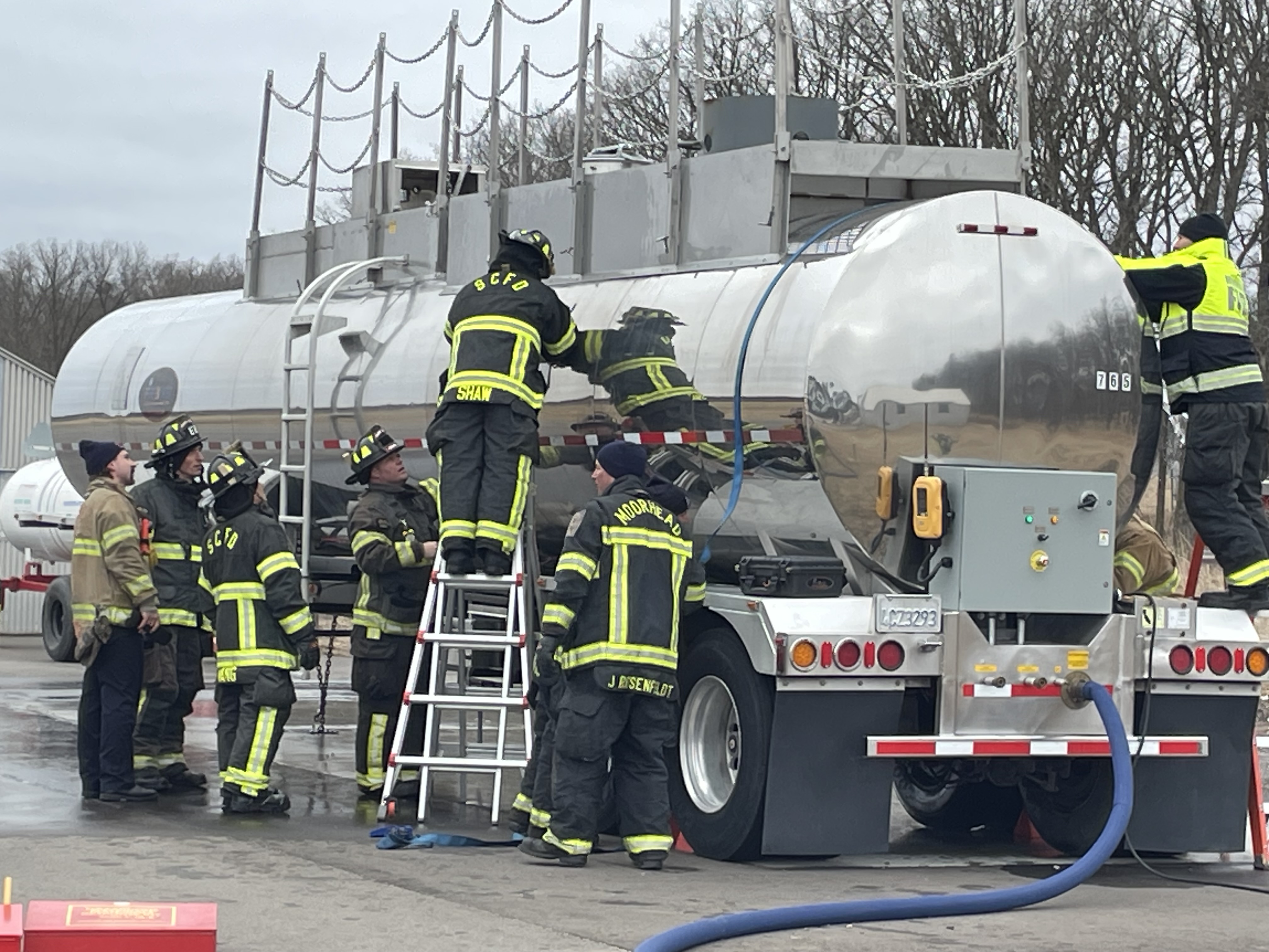 Firefighters conducting ethanol training by crawling around on a semi. 