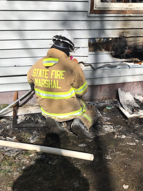 A fire investigator takes a photograph at a fire scene.